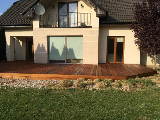 Terraza de madera frente a la casa en el jardín.