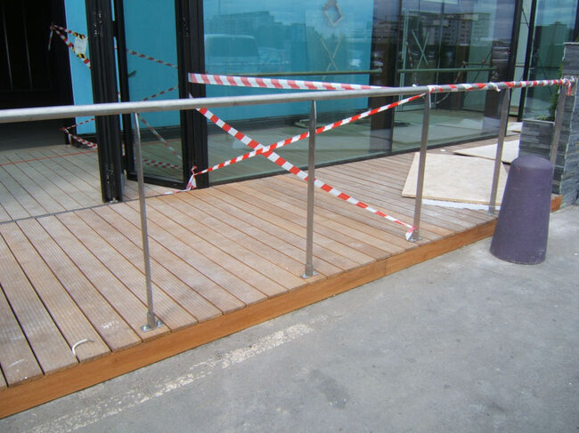 Podest wejściowy z balustradą ze stali nierdzewnej przy budynku.