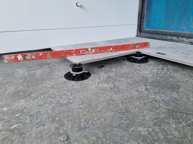 Control de nivel de las baldosas de gres colocadas sobre plots soporte de terraza.