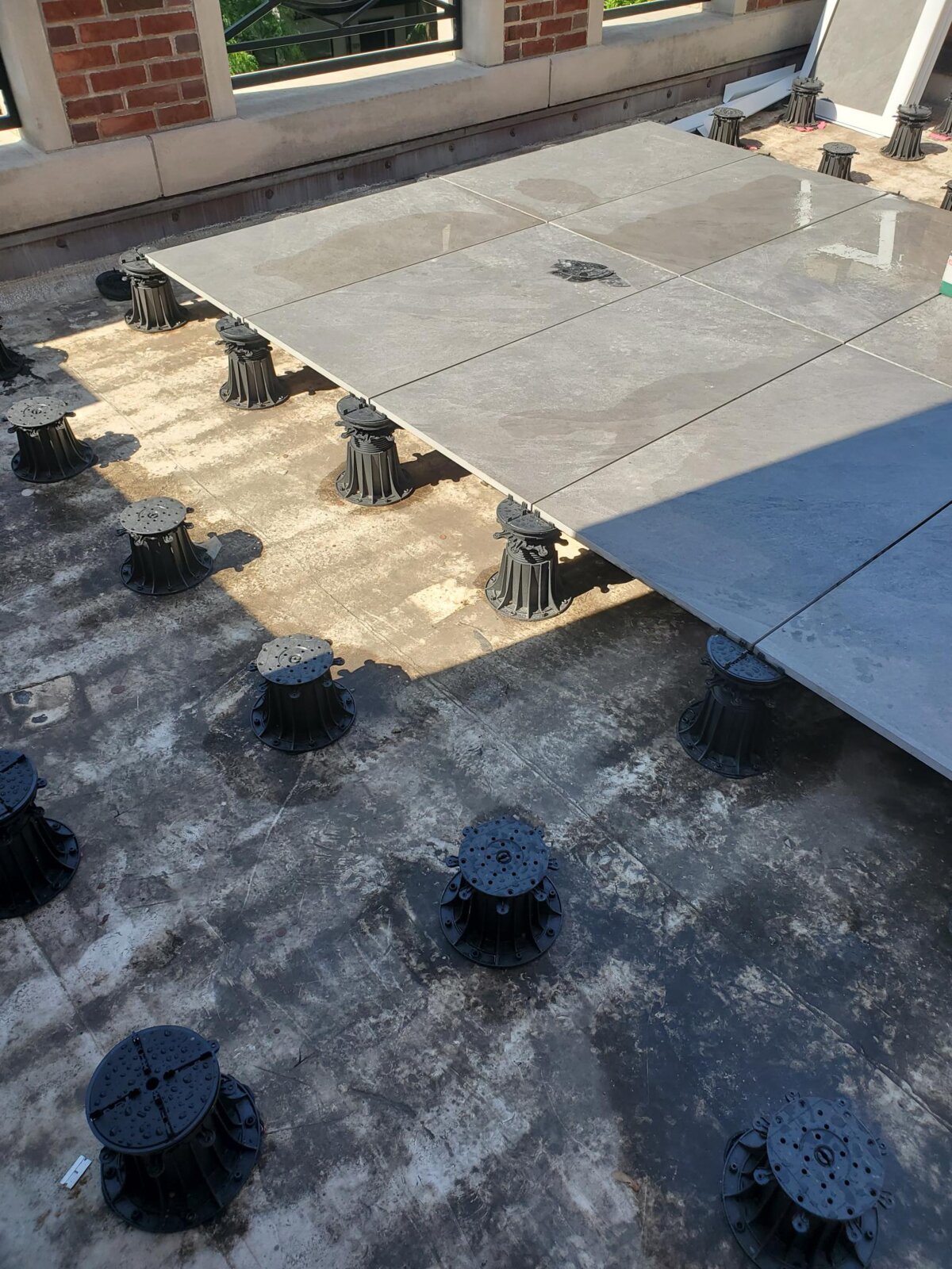 Largo balcón acabado con tablas de terraza de madera con una barandilla moderna.