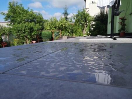 Baldosas cerámicas mojadas en terraza exterior