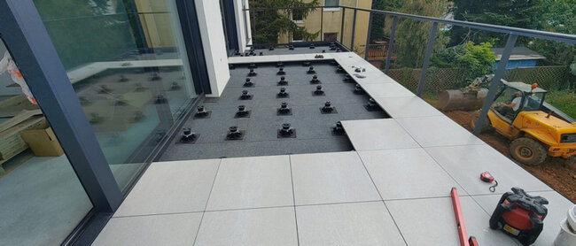 Colocación de baldosas de gres sobre plots soporte de terraza