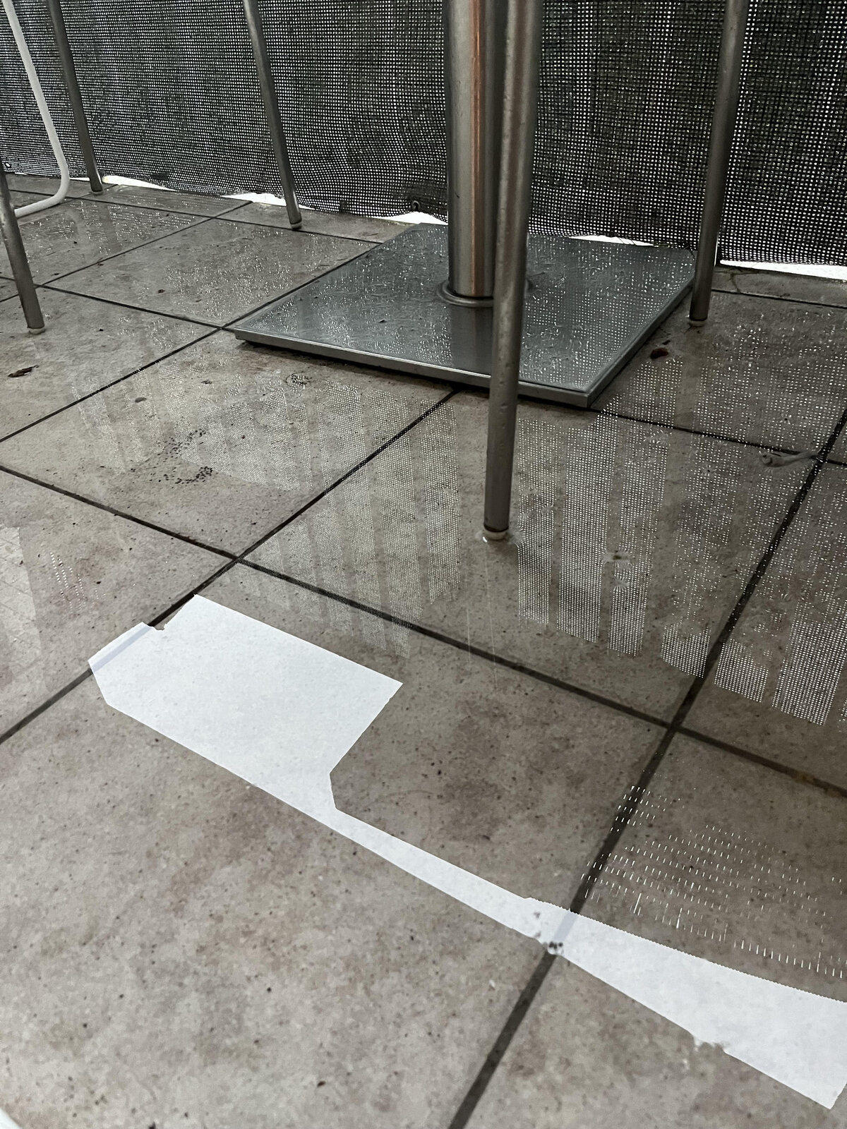 Charco y agua estancada en las baldosas del balcón debajo de los muebles