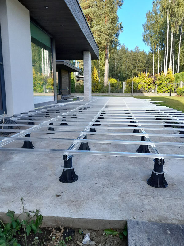 Soportes estándar con adaptadores para vigas colocados con vigas de aluminio en terraza sobre el suelo