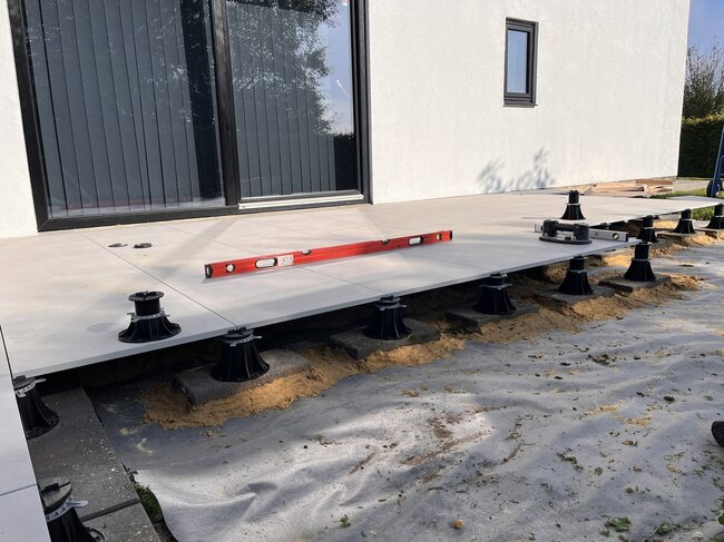 Instalación de baldosas de terraza exterior elevadas utilizando soportes de terraza regulables.