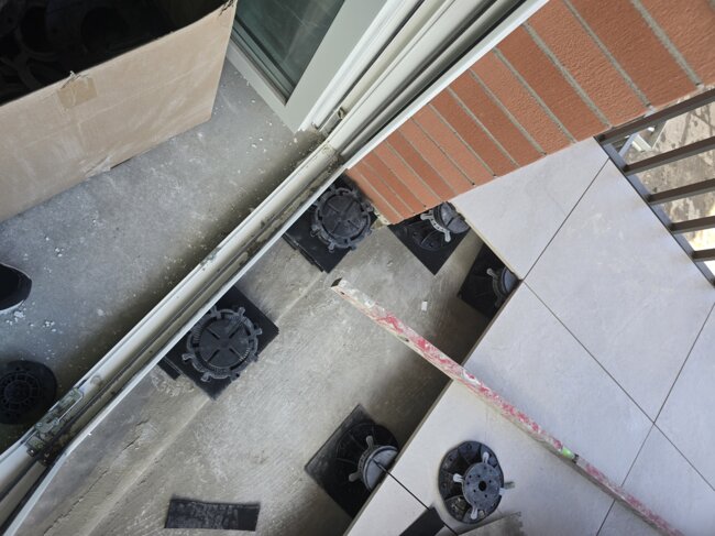 Instalación del sistema de suelo elevado sobre plots soporte para colocar baldosas en un balcón a lo largo del borde.