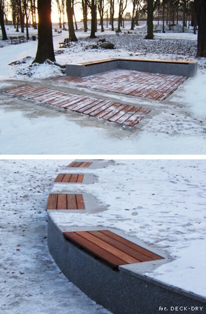 Wooden terrace decking and curved seating benches set in a snowy outdoor landscape during winter.