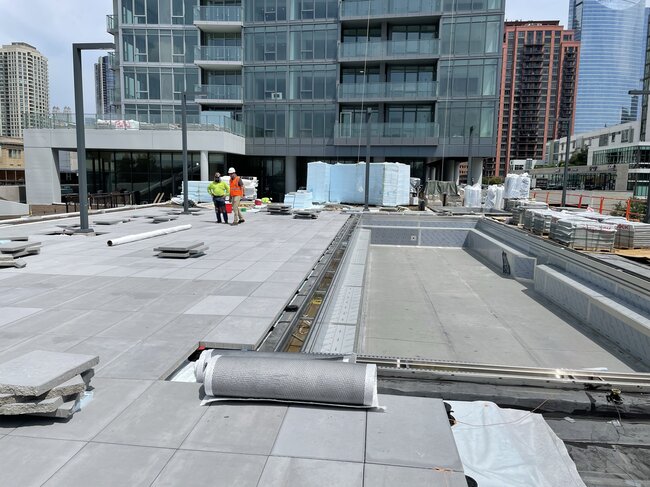 Piscina y terraza comercial en azotea en construcción.