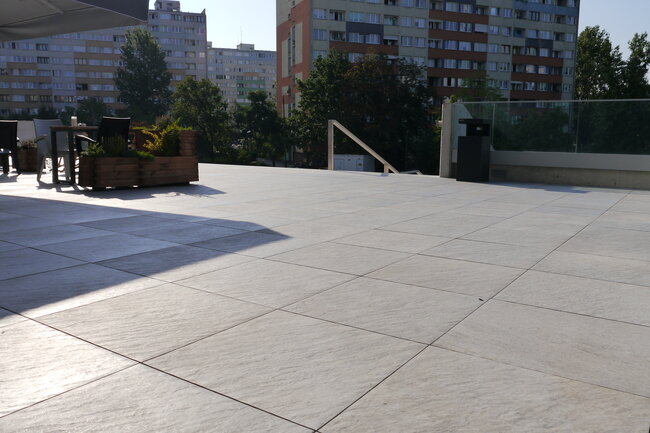 Sistema de baldosas de terraza en cubierta plana instalado sobre plots soporte regulables de terraza.