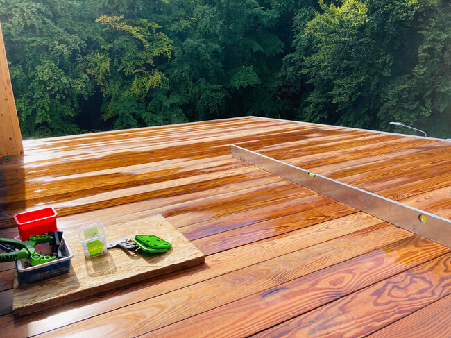 Terraza de madera terminada instalada sobre una terraza elevada utilizando plots soporte regulables.