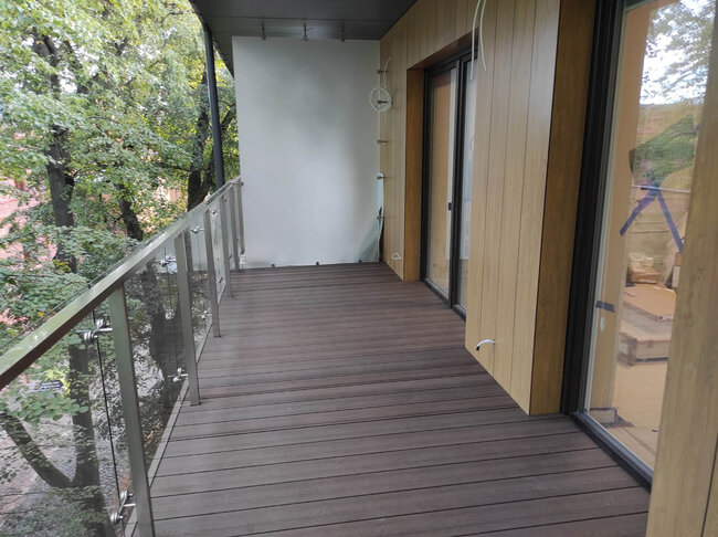 Terraza de composite terminada instalada en un balcón moderno mediante plots soporte regulables.